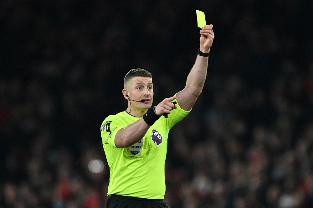 Referee Robert Jones shows a yellow card to Brentford's Nathan Collins (unseen) during the English Premier League football match between Arsenal and Brentford at the Emirates Stadium in London on March 9, 2024. (Photo by JUSTIN TALLIS/AFP via Getty Images)