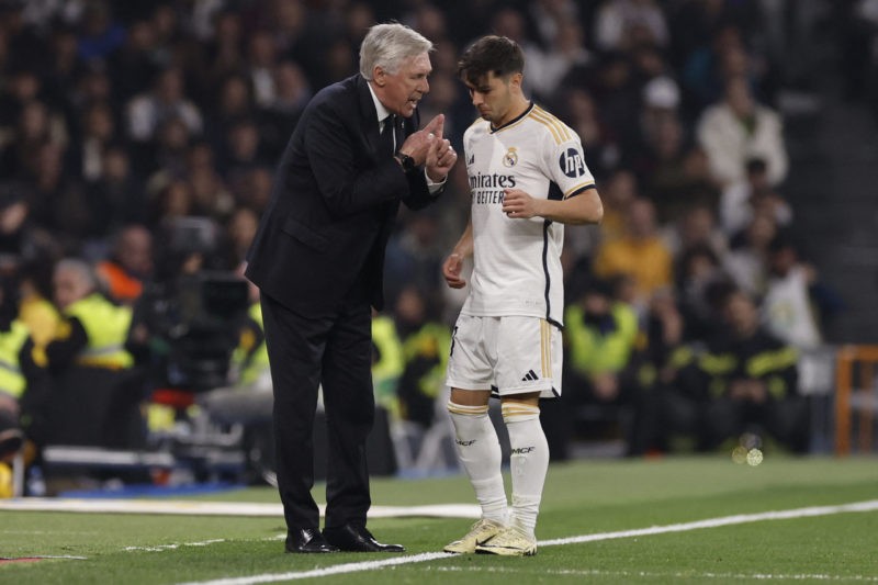 Real Madrid's Italian coach Carlo Ancelotti talks with Real Madrid's Spanish forward #21 Brahim Diaz (R) during the Spanish league football match between Real Madrid CF and Club Atletico de Madrid at the Santiago Bernabeu stadium in Madrid on February 4, 2024. (Photo by OSCAR DEL POZO/AFP via Getty Images)