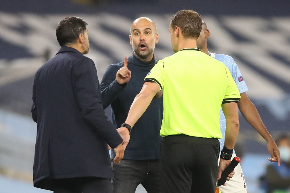 Manchester City's Spanish manager Pep Guardiola (C) gestures as he exchanges words with Porto's Portuguese coach Sergio Conceicao (L) during the UEFA Champions League football Group C match between Manchester City and Porto at the Etihad Stadium in Manchester, north west England on October 21, 2020. (Photo by MARTIN RICKETT/POOL/AFP via Getty Images)