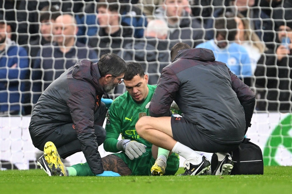 LIVERPOOL, ENGLAND: Ederson of Manchester City receives medical treatment after sustaining an injury and is later substituted off during the Premier League match between Liverpool FC and Manchester City at Anfield on March 10, 2024. (Photo by Michael Regan/Getty Images)