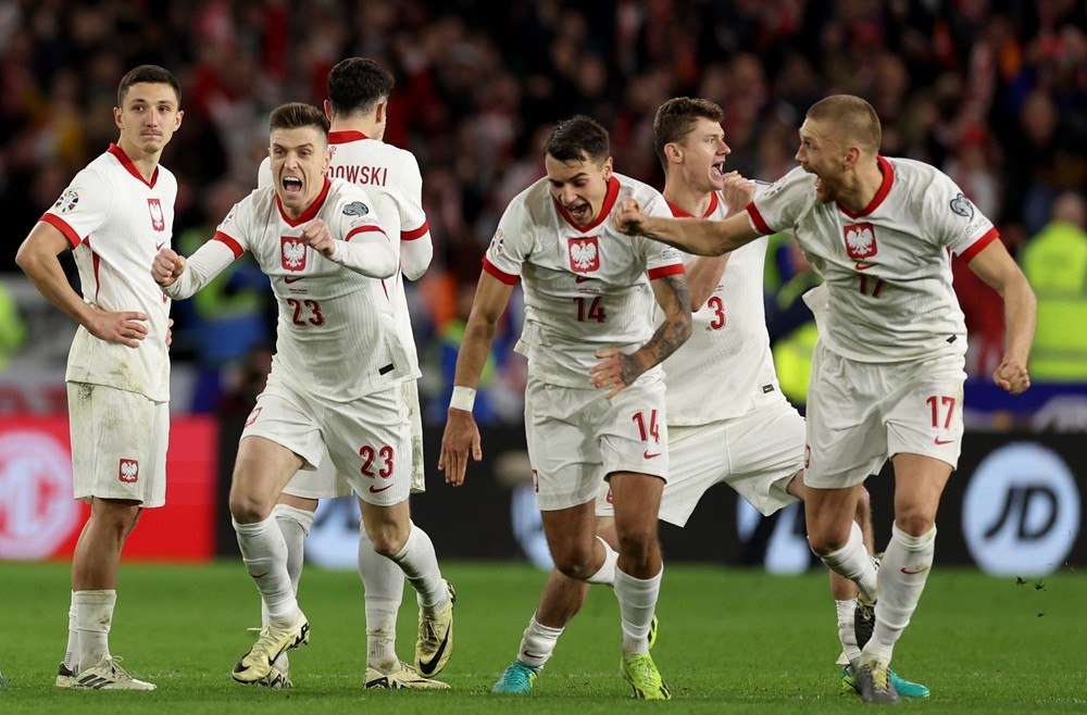 CARDIFF, WALES: Krzysztof Piatek, Jakub Kiwior and Bartosz Salamon of Poland celebrate after victory in the penalty shoot out during the UEFA EURO 2024 Play-Offs Final match between Wales and Poland at Cardiff City Stadium on March 26, 2024. (Photo by Richard Heathcote/Getty Images)