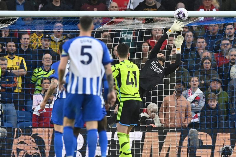 Arsenal's Spanish goalkeeper #22 David Raya makes a save during the English Premier League football match between Brighton and Hove Albion and Arsenal at the American Express Community Stadium in Brighton, southern England on April 6, 2024. (Photo by GLYN KIRK/AFP via Getty Images)