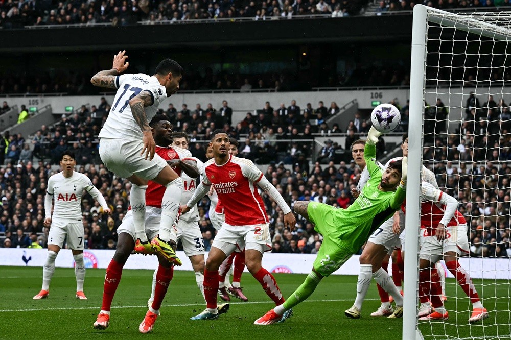 Arsenal's David Raya (R) dives to stop the ball during the English Premier League football match between Tottenham Hotspur and Arsenal at the Tottenham Hotspur Stadium in London, on April 28, 2024. (Photo by BEN STANSALL/AFP via Getty Images)