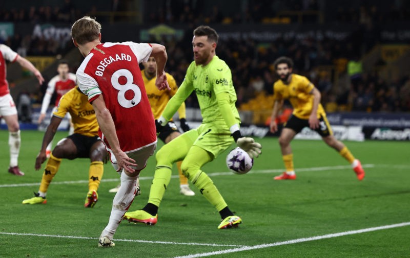 Arsenal's Norwegian midfielder #08 Martin Odegaard (L) scores their second goal during the English Premier League football match between Wolverhampton Wanderers and Arsenal at the Molineux stadium in Wolverhampton, central England on April 20, 2024. (Photo by HENRY NICHOLLS/AFP via Getty Images)