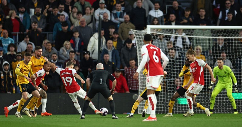 Arsenal's Belgian midfielder #19 Leandro Trossard (4L) shoots to score the opening goal of the English Premier League football match between Wolverhampton Wanderers and Arsenal at the Molineux stadium in Wolverhampton, central England on April 20, 2024. (Photo by HENRY NICHOLLS/AFP via Getty Images)