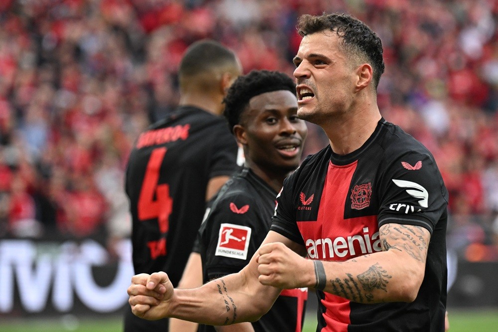 Bayer Leverkusen's Granit Xhaka celebrates scoring the 2-0 goal with his team-mates during the German first division Bundesliga football match Bayer 04 Leverkusen v Werder Bremen in Leverkusen, western Germany, on April 14, 2024. (Photo by INA FASSBENDER/AFP via Getty Images)