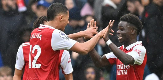 Arsenal's French defender William Saliba (L) celebrates with Arsenal's English midfielder Bukayo Saka (R) after the final whistle of the English Premier League football match between Chelsea and Arsenal at Stamford Bridge in London on November 6, 2022.(Photo by GLYN KIRK/AFP via Getty Images)