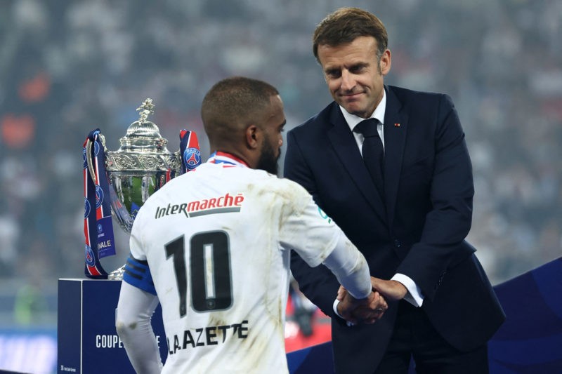 French President Emmanuel Macron (R) shakes hands with Lyon's French forward #10 Alexandre Lacazette on the podium after the French Cup Final football match between Olympique Lyonnais (OL) and Paris Saint-Germain (PSG) at the Stade Pierre-Mauroy, in Villeneuve-d'Ascq, northern France on May 25, 2024. (Photo by FRANCK FIFE/AFP via Getty Images)