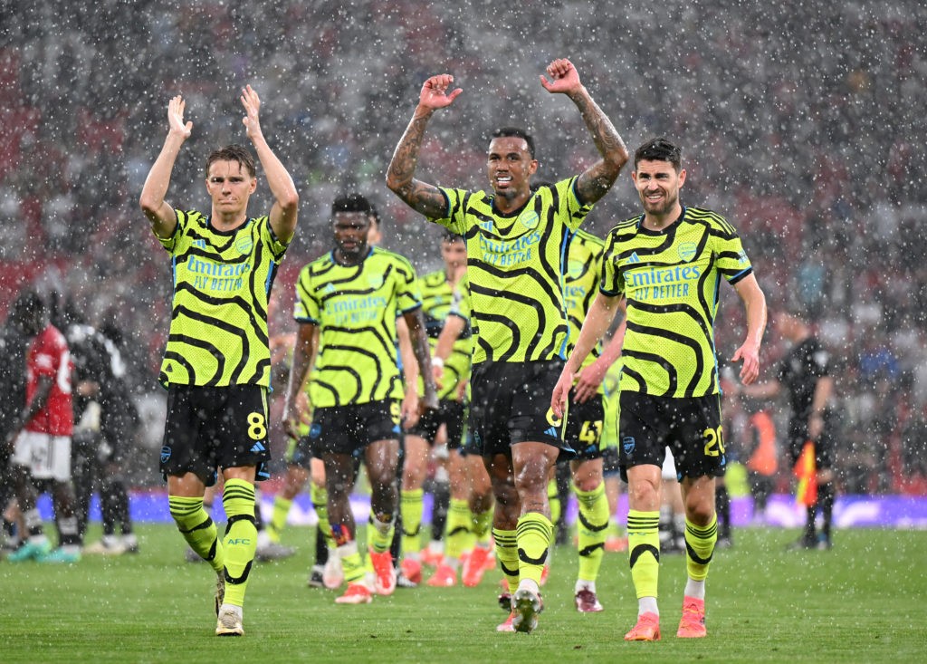 MANCHESTER, ENGLAND - MAY 12: Martin Odegaard, Gabriel and Jorginho of Arsenal celebrate victory as they walk towards their fans after defeating Manchester United during the Premier League match between Manchester United and Arsenal FC at Old Trafford on May 12, 2024 in Manchester, England. (Photo by Michael Regan/Getty Images)