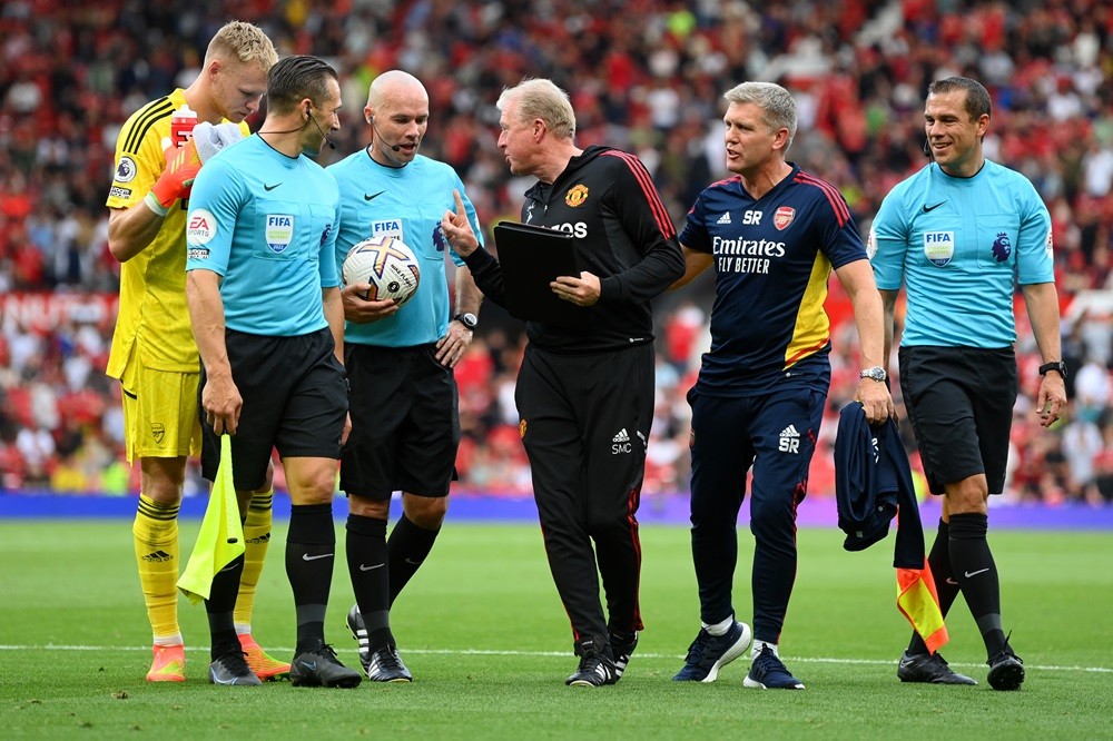 MANCHESTER, ENGLAND: Steve McClaren, Assistant Coach of Manchester United, Steve Round, Coach of Arsenal and Aaron Ramsdale of Arsenal interact with Match Referee Paul Tierney at half time during the Premier League match between Manchester United and Arsenal FC at Old Trafford on September 04, 2022. (Photo by Michael Regan/Getty Images)