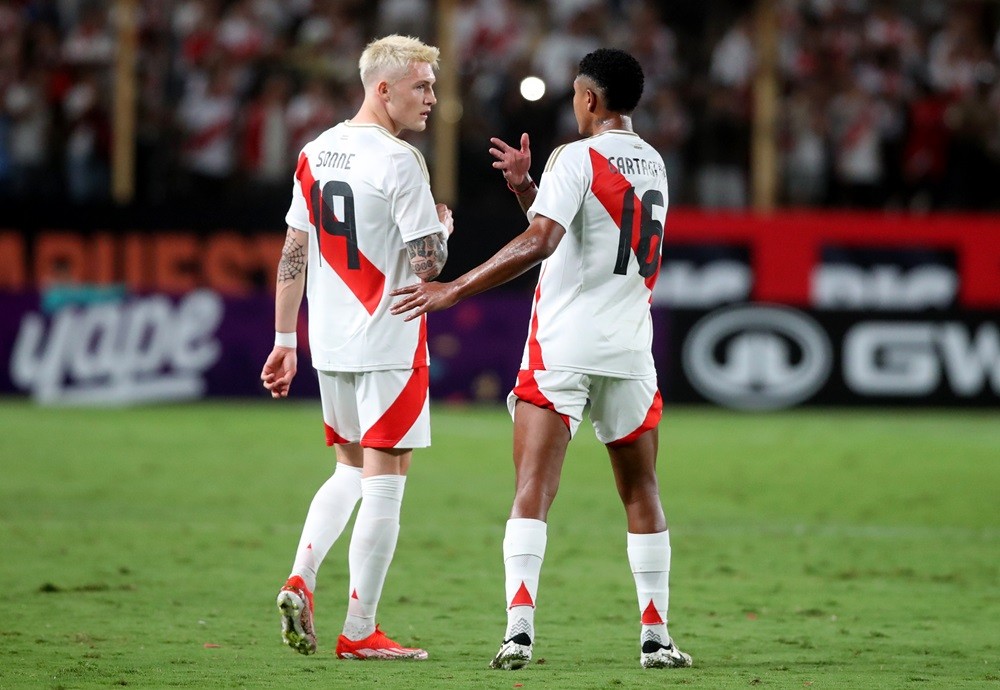 LIMA, PERU: Wilder Cartagena (R) talks to Oliver Sonne (L) during the friendly match between Peru and Dominican Republic at Estadio Monumental on March 27, 2024. (Photo by Raul Sifuentes/Getty Images)