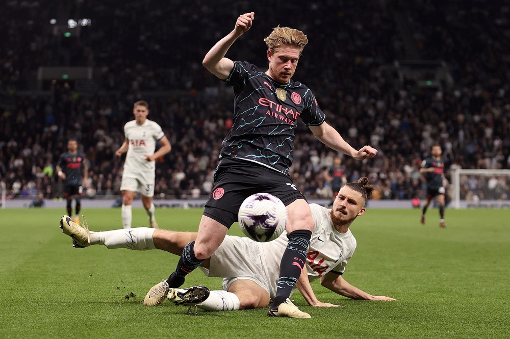 LONDON, ENGLAND: Kevin De Bruyne of Manchester City is challenged by Radu Dragusin of Tottenham Hotspur during the Premier League match between Tottenham Hotspur and Manchester City at Tottenham Hotspur Stadium on May 14, 2024. (Photo by Julian Finney/Getty Images)