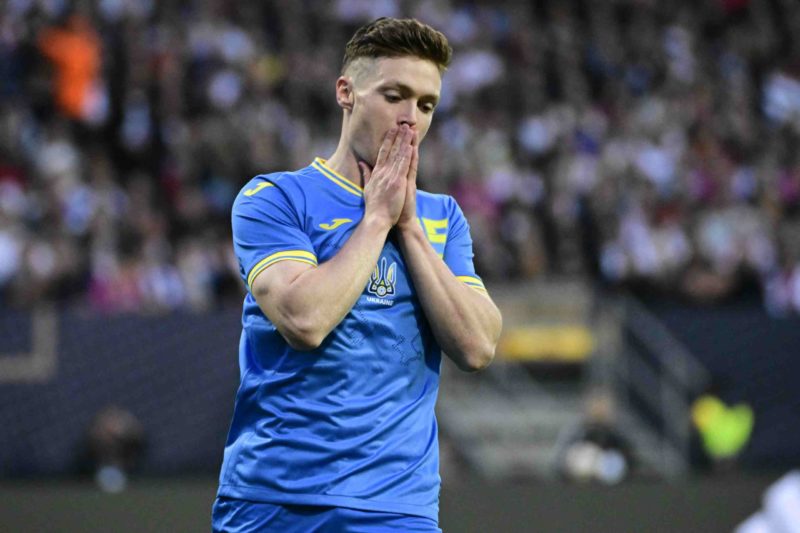 Viktor Tsygankov in a Ukrainian national team jersey, with his hands together in a gesture of contemplation or prayer, on the football field. - Ukraine's midfielder #15 Viktor Tsyhankov reacts after missing an attempt to score during the friendly football match Germany v Ukraine, in Nuremberg, eastern Germany, on June 3, 2024. (Photo by TOBIAS SCHWARZ/AFP via Getty Images)