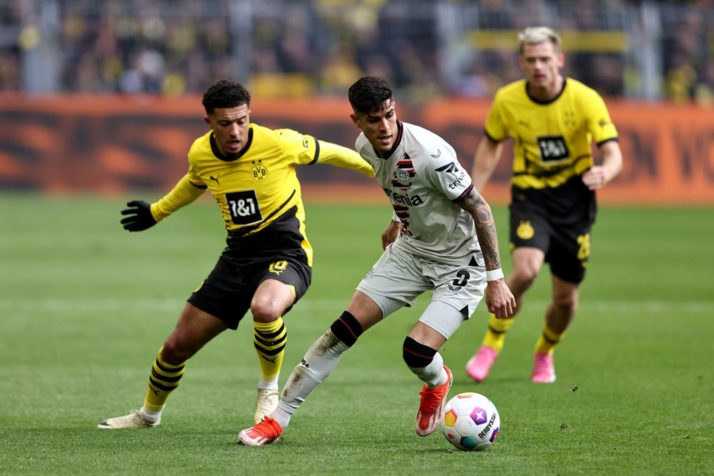 DORTMUND, GERMANY: Piero Hincapie of Bayer Leverkusen is challenged by Jadon Sancho of Borussia Dortmund during the Bundesliga match between Borussia Dortmund and Bayer 04 Leverkusen at Signal Iduna Park on April 21, 2024. (Photo by Christof Koepsel/Getty Images)