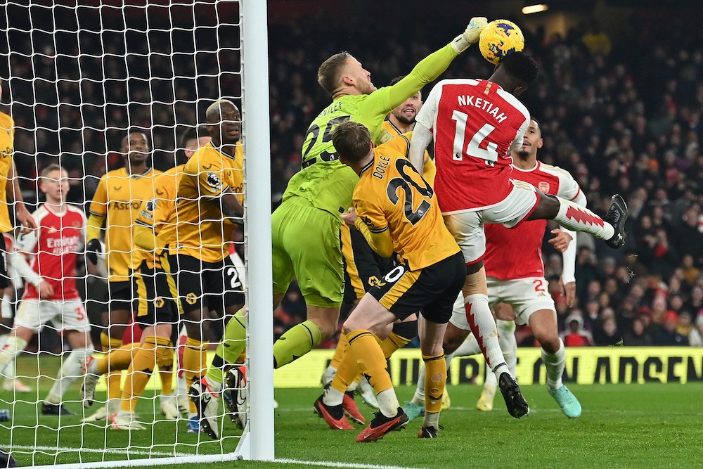 Wolverhampton Wanderers' Dan Bentley punches the ball to save from the head of Arsenal's Eddie Nketiah during the English Premier League football match between Arsenal and Wolverhampton Wanderers at the Emirates Stadium in London on December 2, 2023. (Photo by Glyn KIRK / AFP)