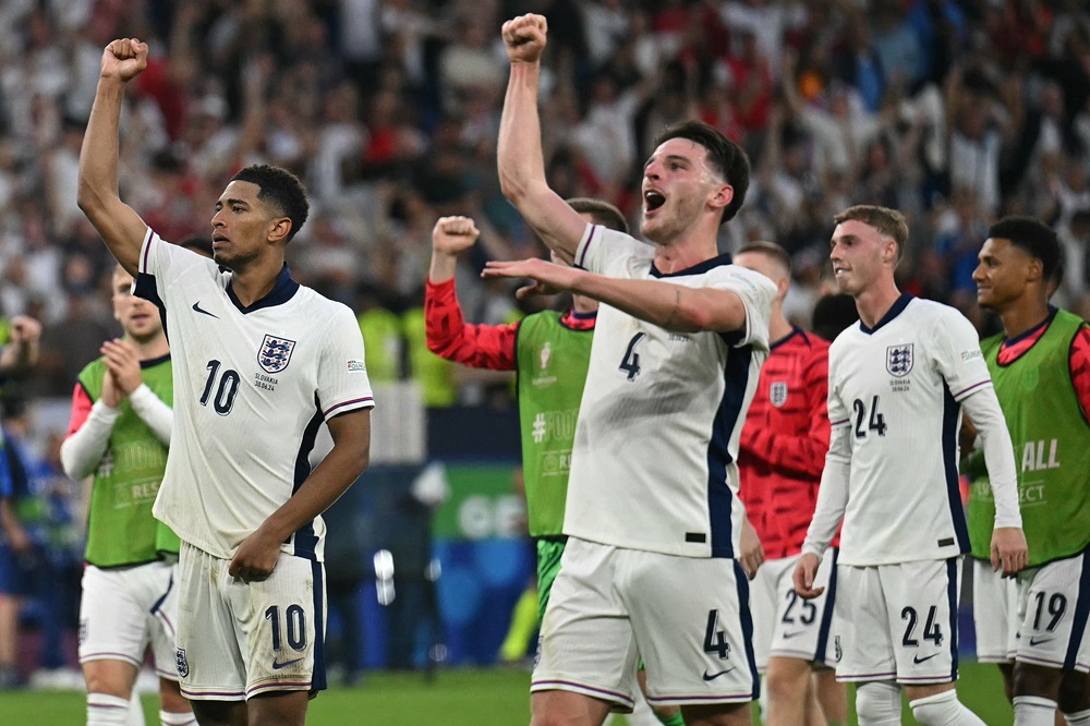 England's Jude Bellingham, Declan Rice, and teammates celebrate with the fans after the UEFA Euro 2024 round of 16 football match between England and Slovakia at the Arena AufSchalke in Gelsenkirchen on June 30, 2024. (Photo by OZAN KOSE/AFP via Getty Images)