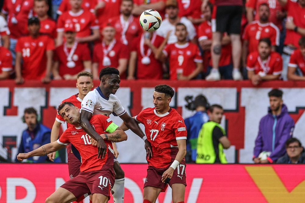 England's Bukayo Saka heads the ball next to Switzerland's Granit Xhaka and Ruben Vargas during the UEFA Euro 2024 quarter-final football match between England and Switzerland at the Duesseldorf Arena in Duesseldorf on July 6, 2024. (Photo by Adrian DENNIS / AFP)