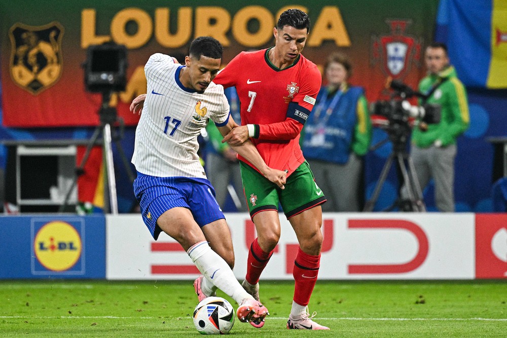 (From L) France's William Saliba and Portugal's Cristiano Ronaldo fight for the ball during the UEFA Euro 2024 quarter-final football match between Portugal and France at the Volksparkstadion in Hamburg on July 5, 2024. (Photo by JAVIER SORIANO / AFP)