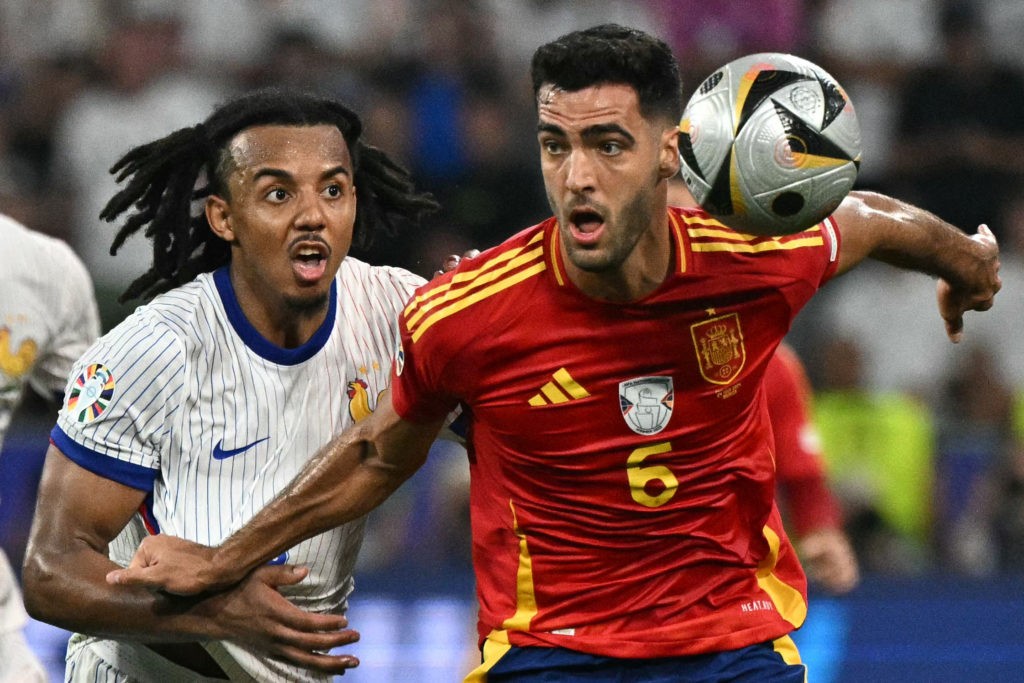 France's defender #05 Jules Kounde fights for the ball with Spain's midfielder #06 Mikel Merino during the UEFA Euro 2024 semi-final football match between Spain and France at the Munich Football Arena in Munich on July 9, 2024. (Photo by JAVIER SORIANO/AFP via Getty Images)