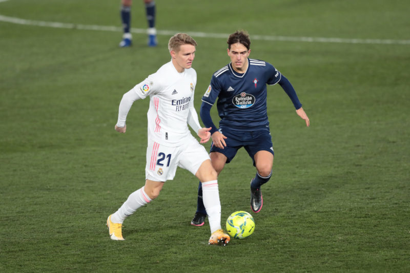 MADRID, SPAIN - JANUARY 02: Martin Oedegaard of Real Madrid battles for possession with Denis Suarez of Celta Vigo during the La Liga Santander match between Real Madrid and RC Celta at Estadio Santiago Bernabeu on January 02, 2021 in Madrid, Spain. Sporting stadiums around Spain remain under strict restrictions due to the Coronavirus Pandemic as Government social distancing laws prohibit fans inside venues resulting in games being played behind closed doors. (Photo by Gonzalo Arroyo Moreno/Getty Images)