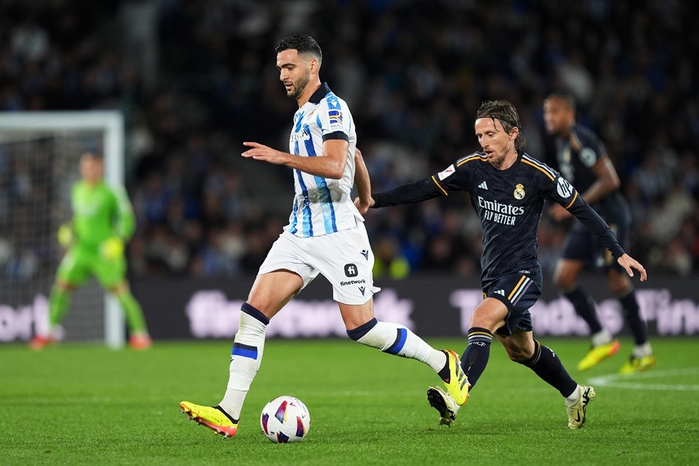 SAN SEBASTIAN, SPAIN: Mikel Merino of Real Sociedad runs with the ball whilst under pressure from Luka Modric of Real Madrid during the LaLiga EA Sports match between Real Sociedad and Real Madrid CF at Reale Arena on April 26, 2024. (Photo by Juan Manuel Serrano Arce/Getty Images)