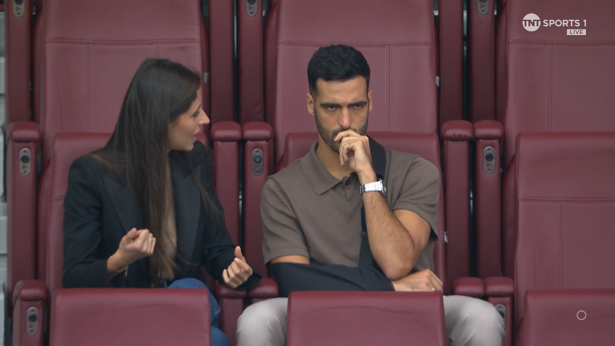 Mikel Merino wearing a sling in the stands during Arsenal's match against Brighton (Photo via TNT Sports)