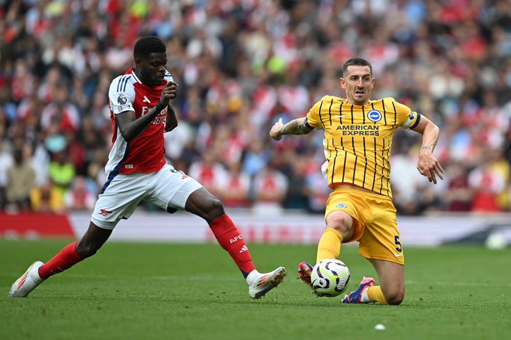 LONDON, ENGLAND: Lewis Dunk of Brighton is challenged by Thomas Partey of Arsenal during the Premier League match between Arsenal FC and Brighton & Hove Albion FC at Emirates Stadium on August 31, 2024. (Photo by Mike Hewitt/Getty Images)