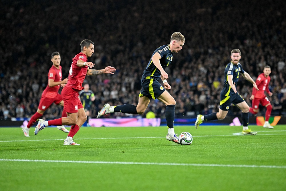 Scotland's Scott McTominay (C) runs with the ball from Poland's Jakub Kiwior (2L) during the UEFA Nations League League A Group 1 football match between Scotland and Poland, at Hampden Park stadium, in Glasgow, on September 5, 2024. (Photo by ANDY BUCHANAN/AFP via Getty Images)