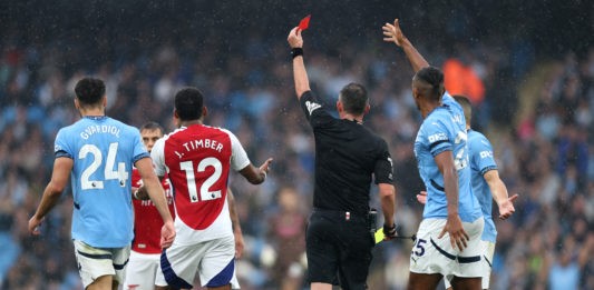 MANCHESTER, ENGLAND - SEPTEMBER 22: Players react as Referee, Michael Oliver shows a red card to Leandro Trossard of Arsenal (obscured) during the Premier League match between Manchester City FC and Arsenal FC at Etihad Stadium on September 22, 2024 in Manchester, England. (Photo by Carl Recine/Getty Images)