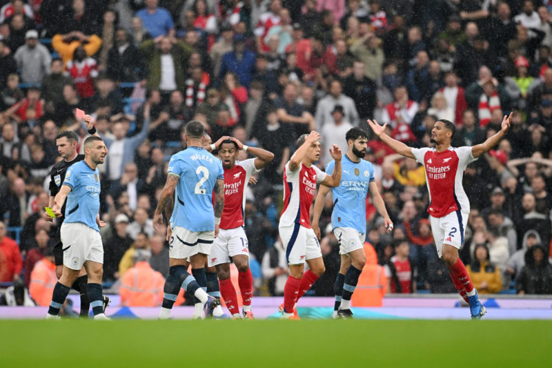 MANCHESTER, ENGLAND - SEPTEMBER 22: Players react as Referee, Michael Oliver shows a red card to Leandro Trossard of Arsenal during the Premier League match between Manchester City FC and Arsenal FC at Etihad Stadium on September 22, 2024 in Manchester, England. (Photo by Michael Regan/Getty Images)