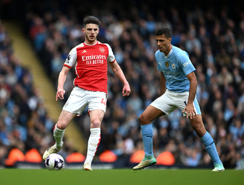 MANCHESTER, ENGLAND - MARCH 31: Declan Rice of Arsenal is challenged by Rodri of Manchester City during the Premier League match between Manchester City and Arsenal FC at Etihad Stadium on March 31, 2024 in Manchester, England. (Photo by Michael Regan/Getty Images)