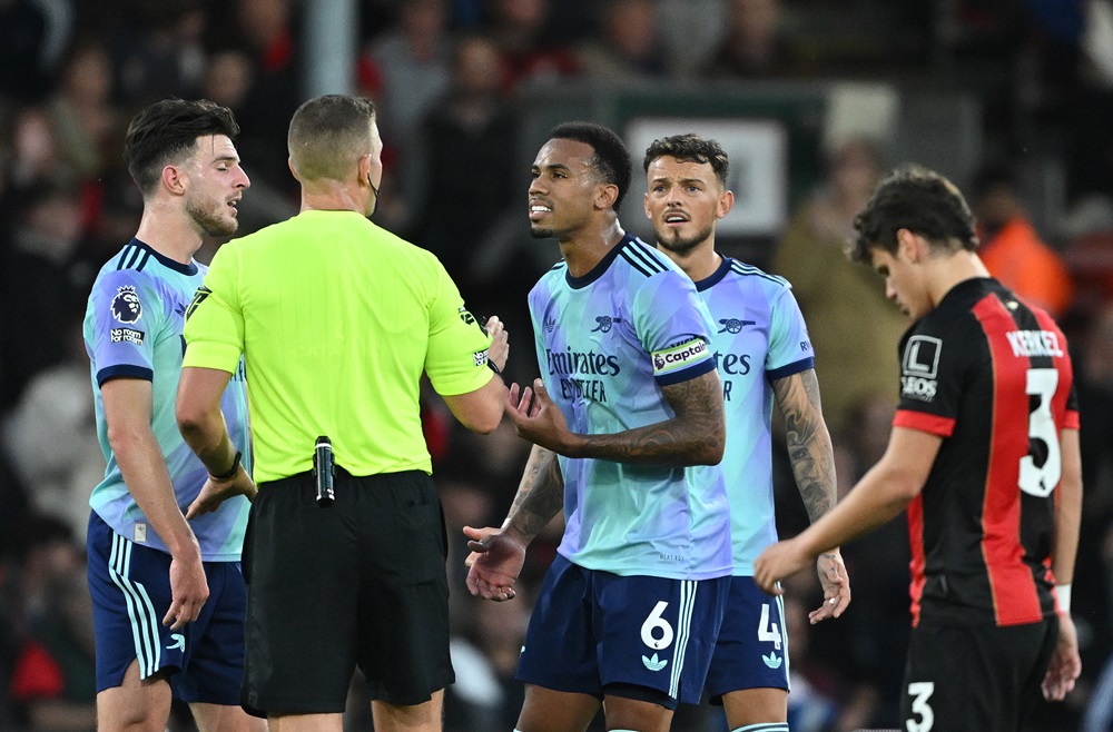 BOURNEMOUTH, ENGLAND: Match Referee, Robert Jones interacts with Gabriel of Arsenal and teammates after showing a red card to their teammate, William Saliba (not pictured) during the Premier League match between AFC Bournemouth and Arsenal FC at Vitality Stadium on October 19, 2024. (Photo by Mike Hewitt/Getty Images)