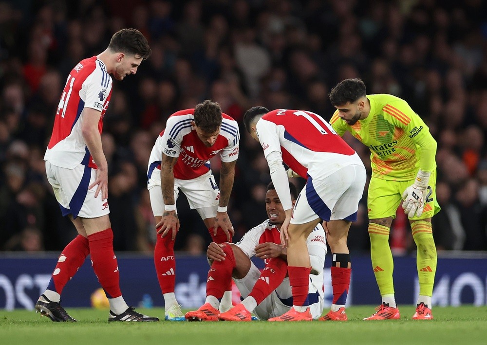 LONDON, ENGLAND: Gabriel of Arsenal reacts as he is checked on by team mates before receiving medial treatment for an injury during the Premier League match between Arsenal FC and Liverpool FC at Emirates Stadium on October 27, 2024. (Photo by Alex Pantling/Getty Images)