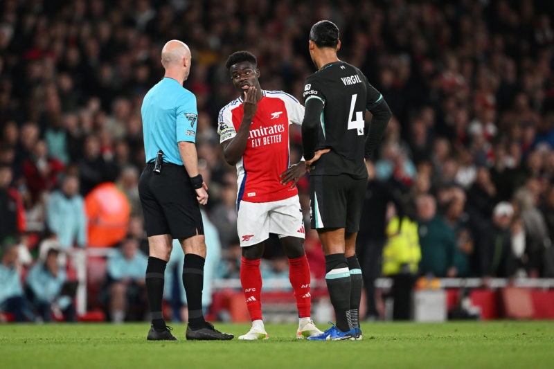 LONDON, ENGLAND - OCTOBER 27: Referee Anthony Taylor looks on as Bukayo Saka of Arsenal and Virgil van Dijk of Liverpool wait for a VAR decision after Mikel Merino of Arsenal (not pictured) scores his team's second goal during the Premier League match between Arsenal FC and Liverpool FC at Emirates Stadium on October 27, 2024 in London, England. (Photo by Shaun Botterill/Getty Images)