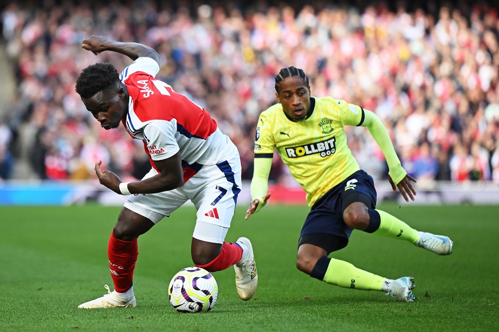 LONDON, ENGLAND: Bukayo Saka of Arsenal is challenged by Kyle Walker-Peters of Southampton during the Premier League match between Arsenal FC and Southampton FC at Emirates Stadium on October 05, 2024. (Photo by Clive Mason/Getty Images)