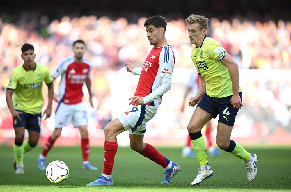 LONDON, ENGLAND: Kai Havertz of Arsenal passes the ball under pressure from Flynn Downes of Southampton during the Premier League match between Arsenal FC and Southampton FC at Emirates Stadium on October 05, 2024. (Photo by Clive Mason/Getty Images)