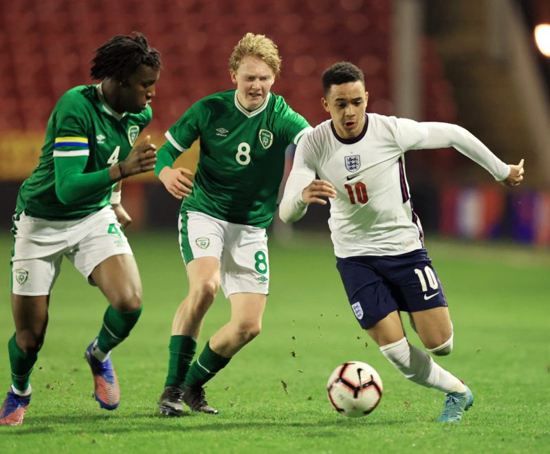 WALSALL, ENGLAND - MARCH 23: Aaron Ramsey of England runs with the ball whilst under pressure from Mohammed Olabosun Lawal and Jack Henry-Francis of Republic of Ireland during the UEFA European Under-19 Championship Qualifying match between England MU19 and Republic of Ireland U19 on March 23, 2022 in Walsall, England. (Photo by David Rogers/Getty Images)