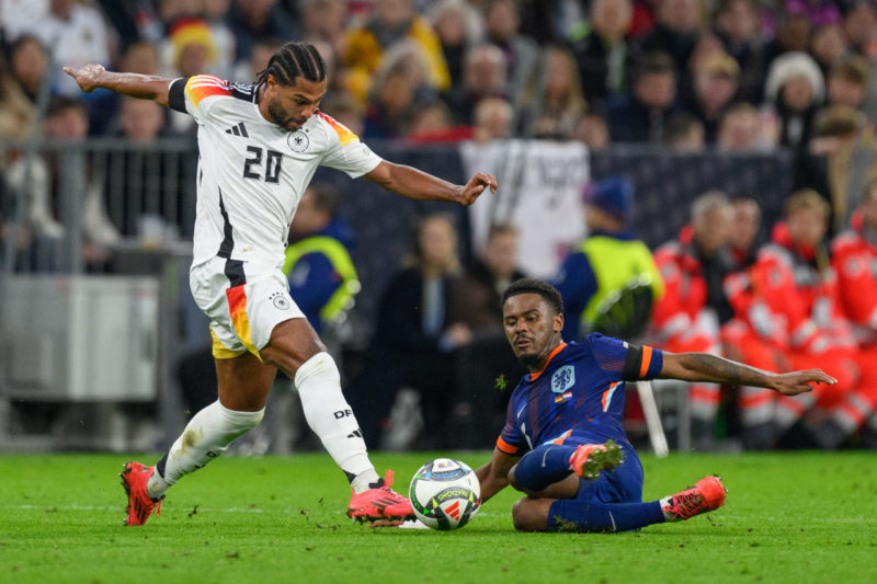 MUNICH, GERMANY - OCTOBER 14: Serge Gnabry of Germany challenges Jorrel Hato of Netherlands during the UEFA Nations League 2024/25 League A Group A3 match between Germany and Netherlands at on October 14, 2024 in Munich, Germany. (Photo by Christian Kaspar-Bartke/Getty Images for DFB)