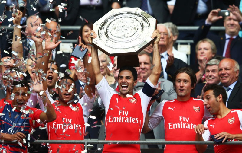 LONDON, ENGLAND - AUGUST 10: Captain Mikel Arteta of Arsenal holds up the trophy alongside team-mates Alex Oxlade-Chamberlain (L) Tomas Rosicky and Santi Cazorla after winning the FA Community Shield match between Manchester City and Arsenal at Wembley Stadium on August 10, 2014 in London, England. (Photo by Clive Mason/Getty Images)