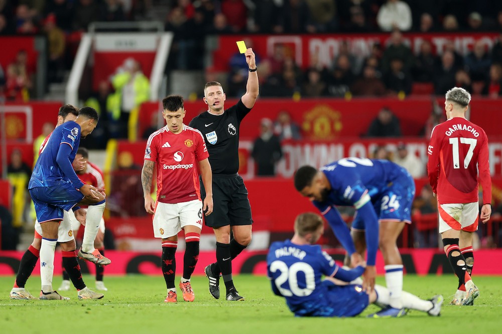 MANCHESTER, ENGLAND: Lisandro Martinez of Manchester United is shown a yellow card from referee Robert Jones after a foul on Cole Palmer of Chelsea during the Premier League match between Manchester United FC and Chelsea FC at Old Trafford on November 03, 2024. (Photo by Carl Recine/Getty Images)