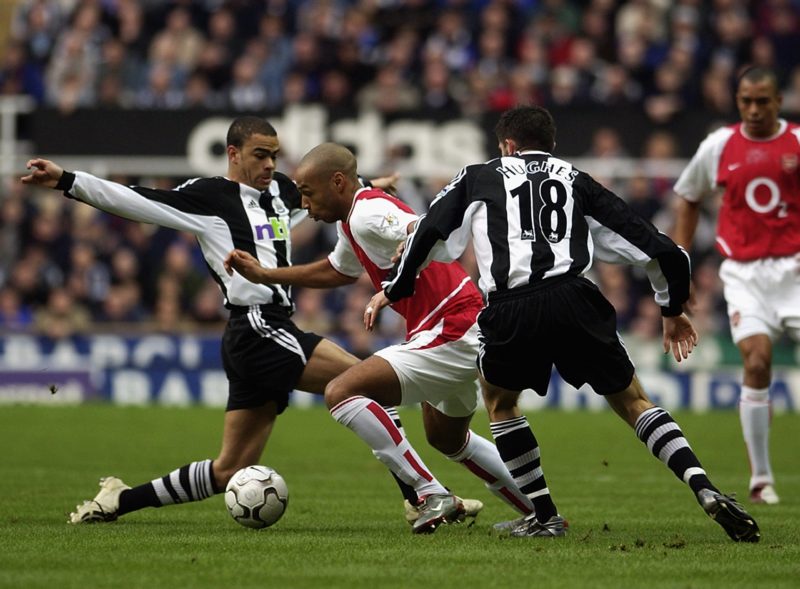 NEWCASTLE - FEBRUARY 9: Thierry Henry of Arsenal takes the ball past Aaron Hughes and Kieron Dyer of Newcastle United during the FA Barclaycard Premiership match held on February 9, 2003 at St James Park, in Newcastle, England. The match ended in a 1-1 draw. (Photo by Ross Kinnaird/Getty Images)