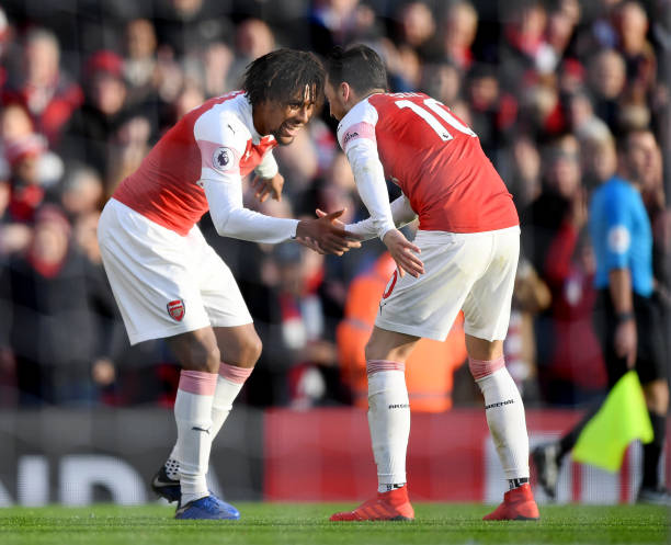 LONDON, ENGLAND - DECEMBER 22: Alex Iwobi of Arsenal celebrates after scoring his team's third goal with Mesut Ozil of Arsenal during the Premier League match between Arsenal FC and Burnley FC at Emirates Stadium on December 22, 2018 in London, United Kingdom. (Photo by Shaun Botterill/Getty Images)